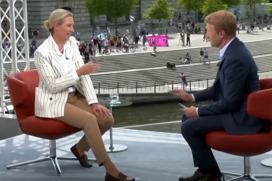 Anti-AfD protesters disrupt a live ARD interview with Alice Weidel in Berlin, blasting music and chanting below the stage as part of a loud demonstration against far-right politics in Germany.