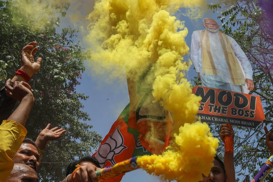 BJP supporters celebrate their party's lead in the Assam and West Bengal state election results at the BJP headquarters in New Delhi.