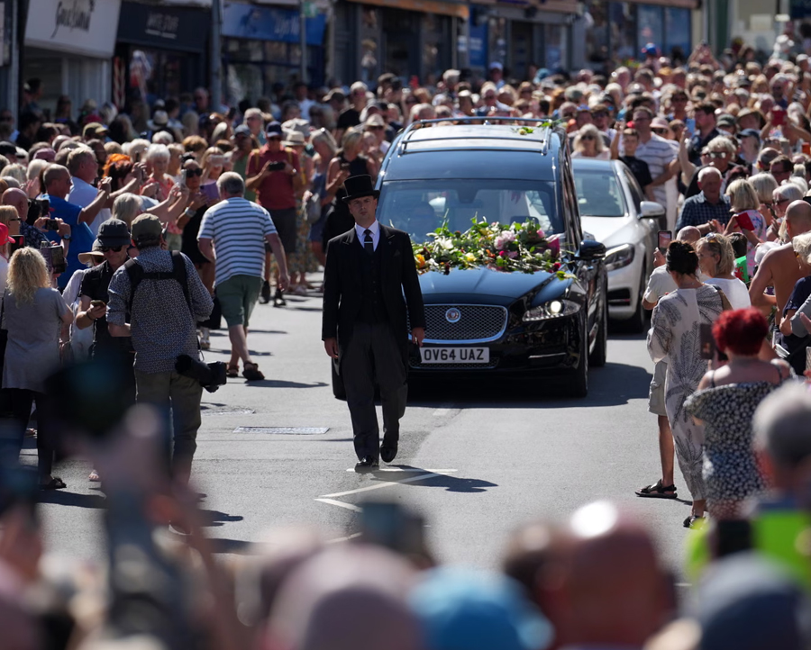 Fans of singer Bonnie Tyler line the streets as her coffin is taken back to her former home ahead of her funeral, in Mumbles, Wales