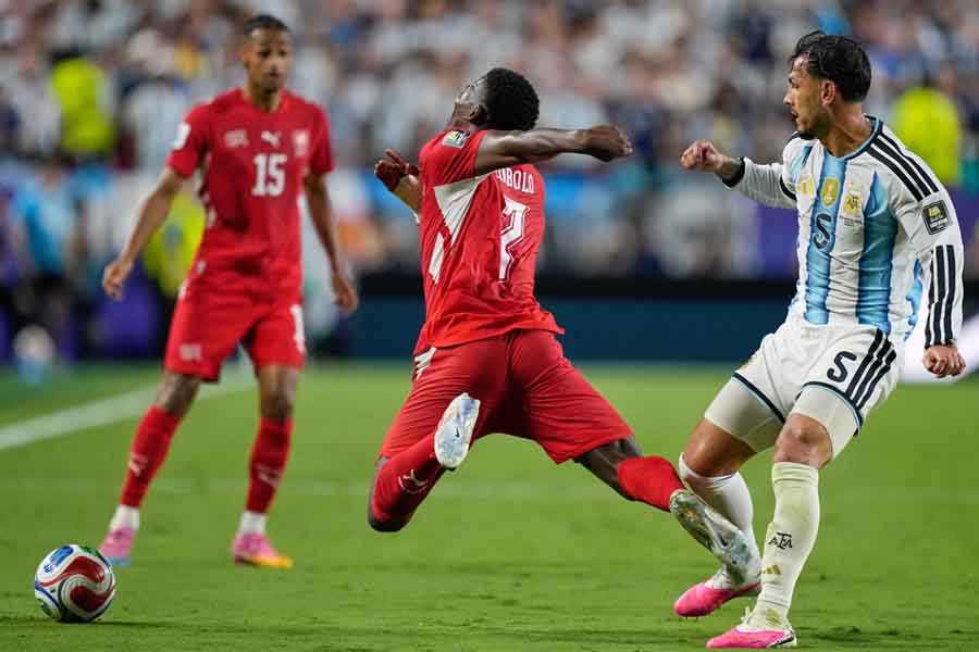 Switzerland's Breel Embolo dives after a challenge from Leandro Paredes