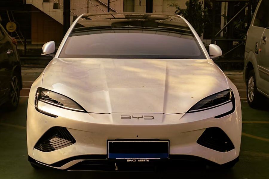 A BYD white electric sports car parked in a parking lot. The Chinese EV maker aims to overtake Toyota as the world's largest automaker within five years.