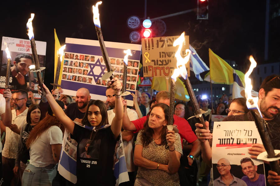 Protesters gather outside Prime Minister Netanyahu’s office in Jerusalem, demanding an immediate ceasefire in Gaza and the release of Israeli hostages. Signs and banners call for peace and humanitarian action amid escalating tensions.