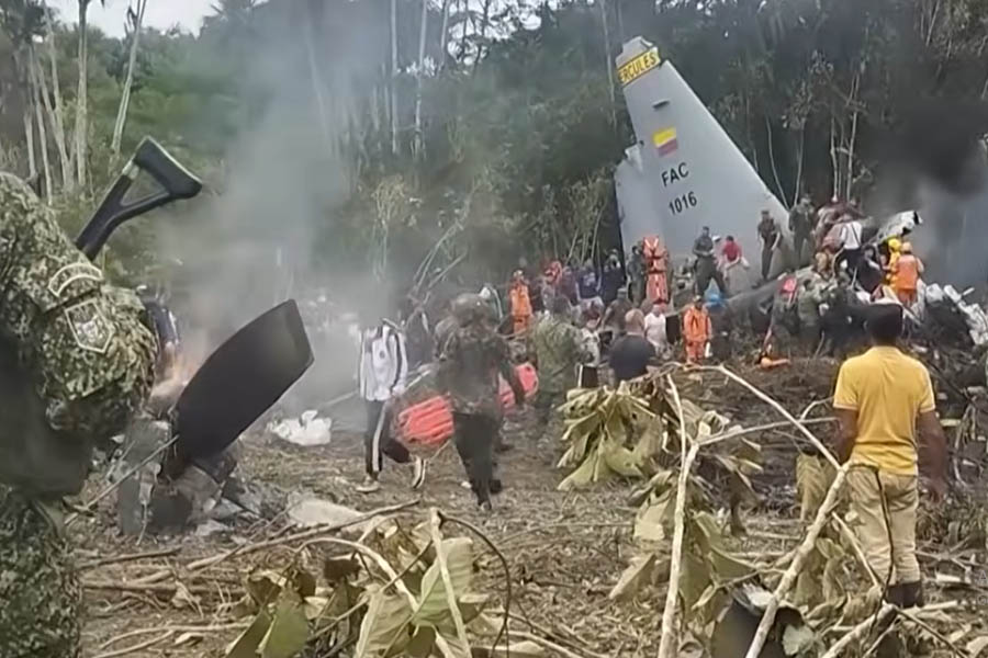 Burning wreckage of a Colombian Air Force Hercules C-130 plane at the crash site in Puerto Leguízamo, showing smoke rising and emergency response underway