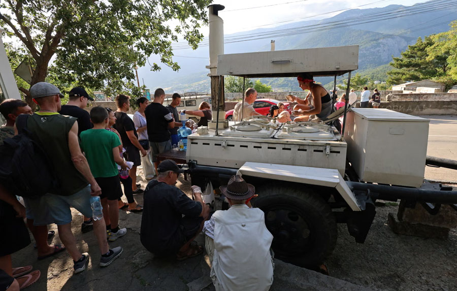 People line up for meals at a field kitchen in Massandra, Crimea