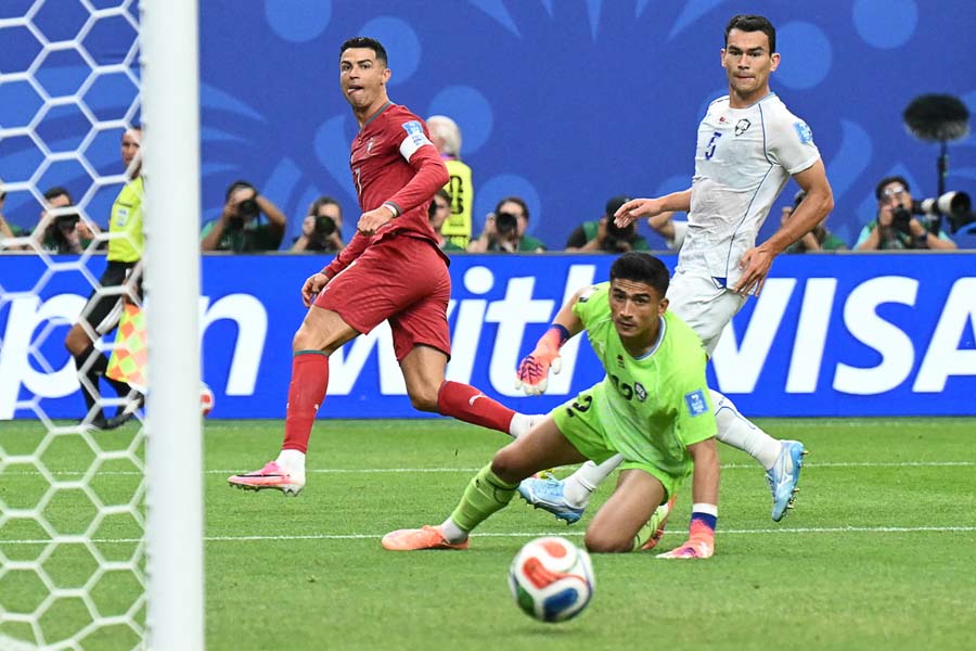 Cristiano Ronaldo watches his shot go in to mark his second goal of the game, and Portugal's third. The 41-year-old became the first player to score in six World Cups.