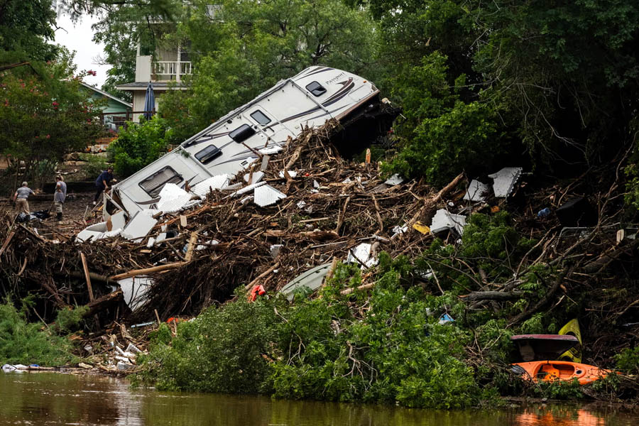 A wrecked motorhome lies abandoned along the banks of the Guadalupe River in Louise Hays Park, Kerrville, Texas, as flood survivors express anger over inadequate safety planning and a delayed official response amid the deadly disaster.