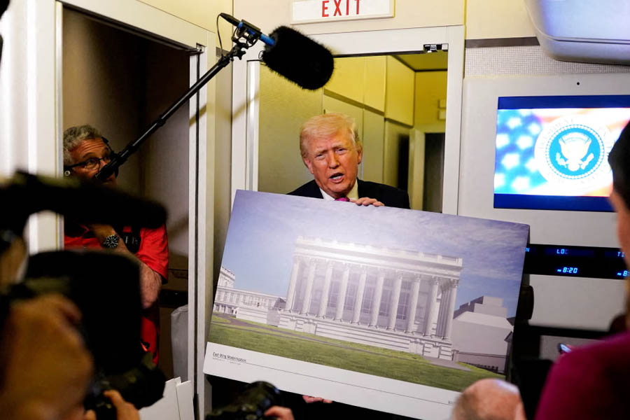 Donald Trump speaks to members of the media onboard Air Force One on Sunday, holding up renderings of the planned White House ballroom.