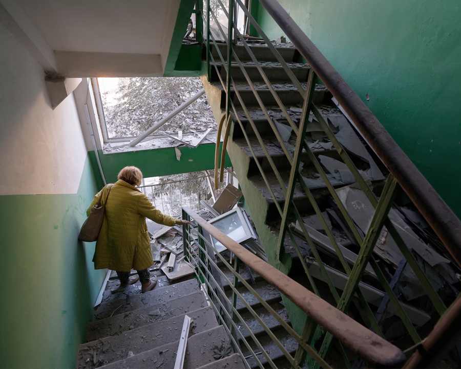 An elderly woman walks to inspect her damaged flat at the site of a Russian missile strike on a nine-storey residential building in Kyiv, Ukraine.