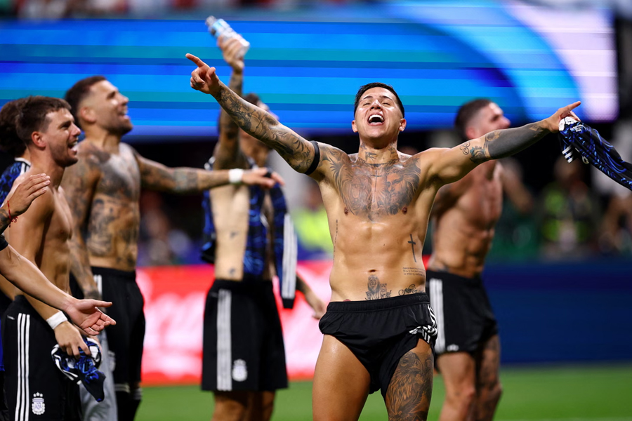 Argentina's Enzo Fernandez whips off his kit and celebrates with team-mates