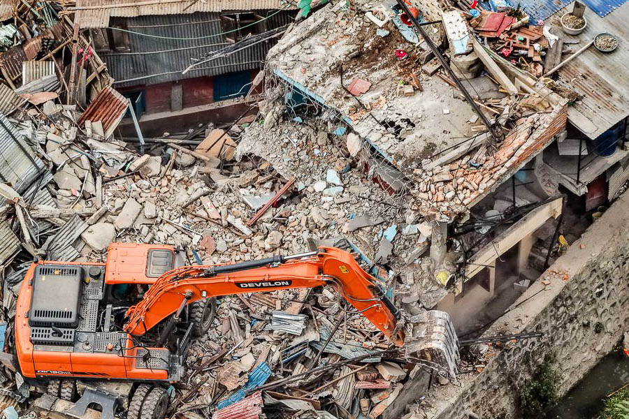 A bulldozer demolishes unauthorized structures in Gairigaun, Kathmandu, during the government's anti-encroachment operation targeting riverside settlements.