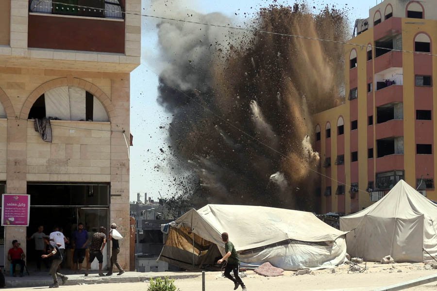People run away from a targeted building in Gaza City