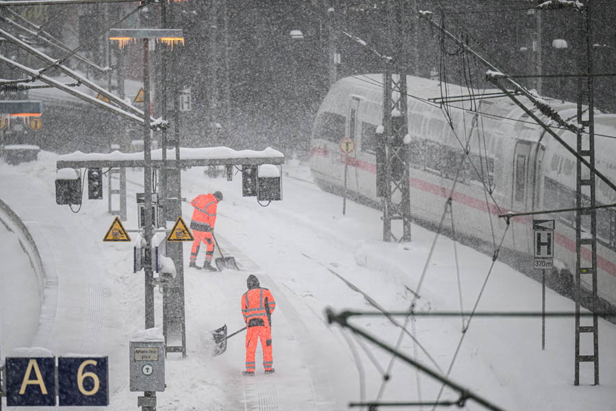 Workers clearing snow from the platforms at Hamburg’s main railway station during heavy snowfall caused by Storm Goretti in northern Germany.