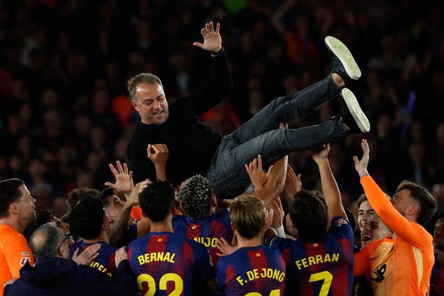 Barcelona head coach Hansi Flick is lifted up by his players after the 2-0 win over Real Madrid secured the La Liga title.