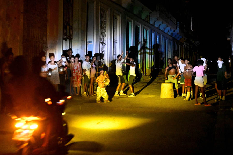 Residents in Havana stand on the street amid darkness following Cuba’s nationwide blackout, highlighting the impact of the collapsed electric grid on daily life.