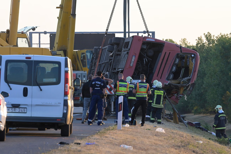A crane lifts the bus from the side of the motorway