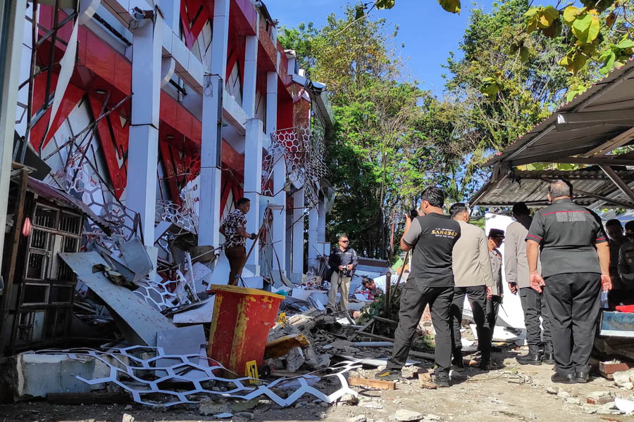 Police inspect structural damage after a powerful 7.4-magnitude offshore earthquake struck near Manado, North Sulawesi, Indonesia.