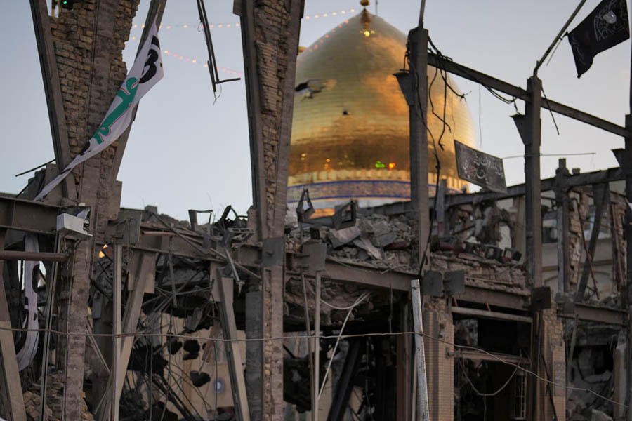 People look at a destroyed building within the Grand Hosseiniyeh, with the mosque visible in the background. Officials at the site in Zanjan, Iran, say it was hit by US-Israeli airstrikes at the weekend.
