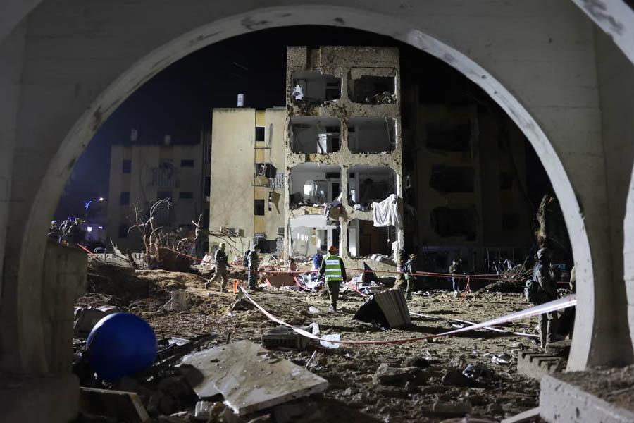 Israeli security personnel, emergency responders, and paramedics at the site of an Iranian missile impact in Arad, southern Israel, March 22, 2026, amid rescue operations and damage assessment.