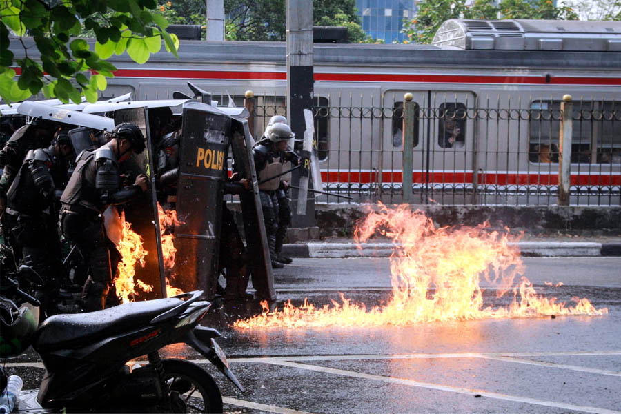 Indonesian police officers under attack with a Molotov cocktail during mass protest demanding dissolution of parliament near the House of Representatives building in Jakarta, August 25, 2025.