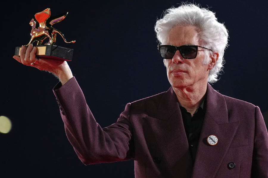 Jim Jarmusch proudly holding the Golden Lion trophy after winning best film at the Venice Film Festival.