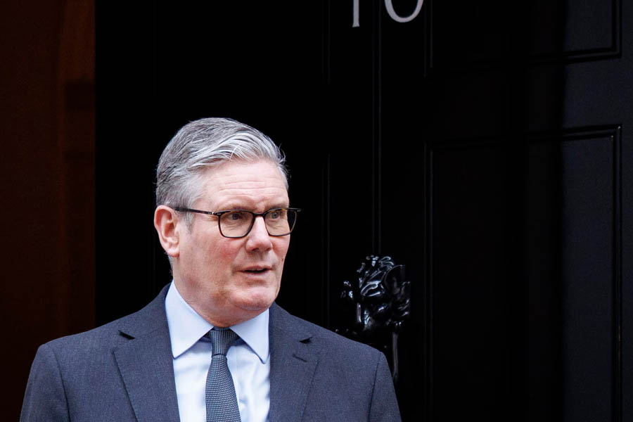 Keir Starmer seated at a conference table, ready to lead an emergency UK government meeting on economic risks.