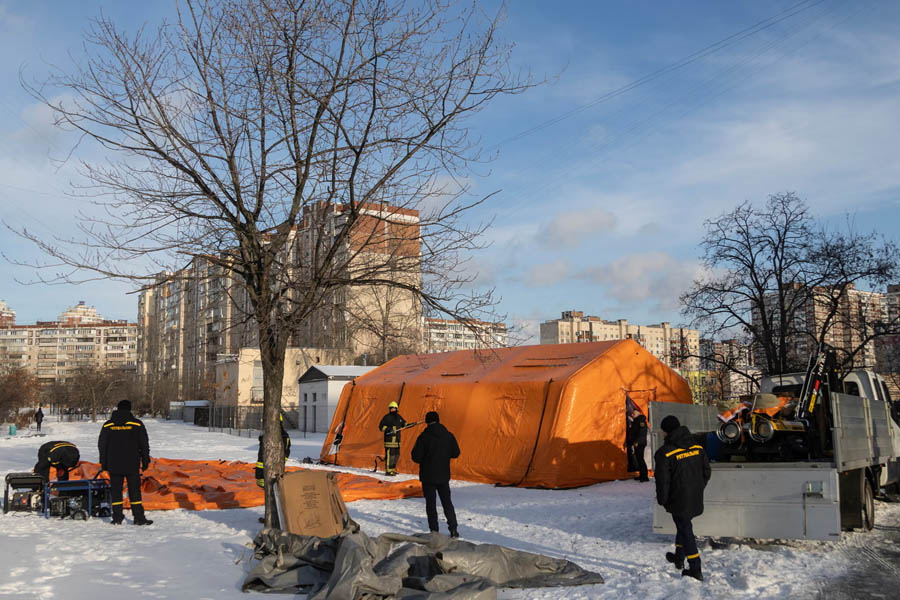 Kyiv emergency service workers installing warming tents for civilians after Russian attacks cut heating and power in the Ukrainian capital during winter.