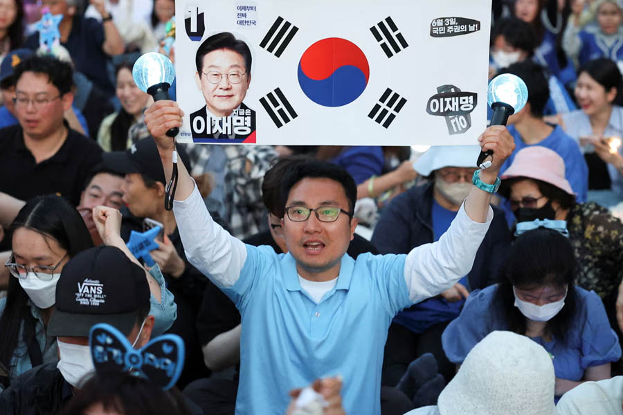 Supporters of Lee Jae-myung react to a television report of the exit poll, near the national assembly in Seoul.
