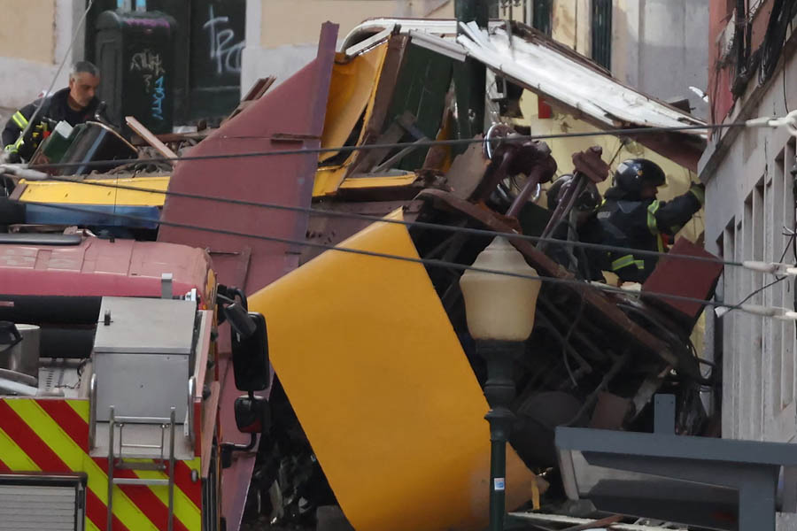 Lisbon funicular derailment showing the crashed car against a building on a narrow street after careening downhill.