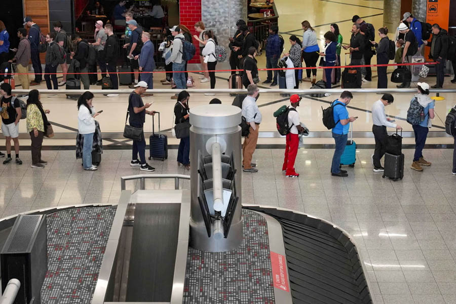 Long queues of travelers waiting at security checkpoints inside Hartsfield-Jackson Atlanta International Airport due to delays and staffing issues