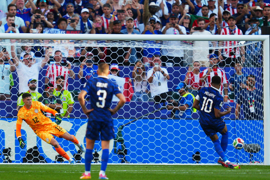 Paraguay goalkeeper Orlando Gill goes the wrong way as Kylian Mbappe keeps his cool to score from the spot