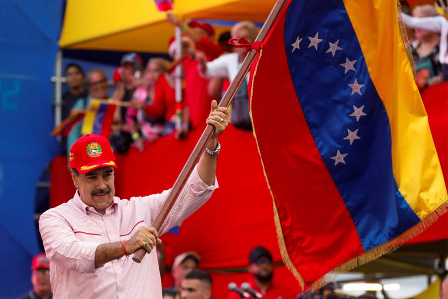 Nicolás Maduro waving a Venezuelan flag during a ceremony to swear in new community-based organisations on Monday.