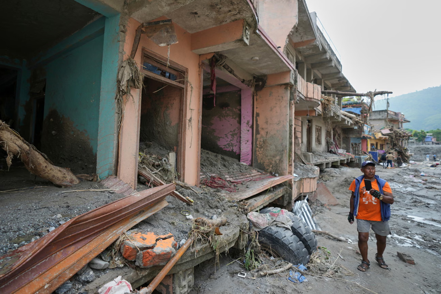 A man walks past damaged structures after flash flooding in the Devighat area of Nuwakot district in Nepal, Friday, Aug. 28, 2026.