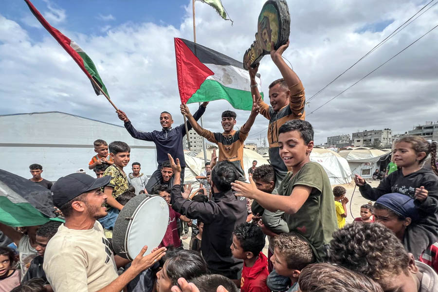 Palestinians gather and celebrate in Nusairat Camp after news of a Gaza ceasefire agreement.