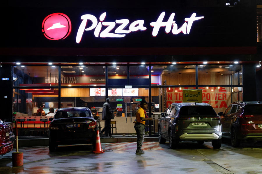 A security guard stands in front of a Pizza Hut in Abidjan, Ivory Coast, on 5 October 2024. The iconic pizza chain is being sold for $2.7bn as its parent company Yum! Brands focuses on stronger-performing brands.