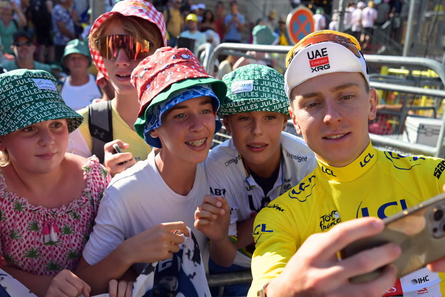 Tadej Pogacar takes selfies with fans after his third stage win of this year's race