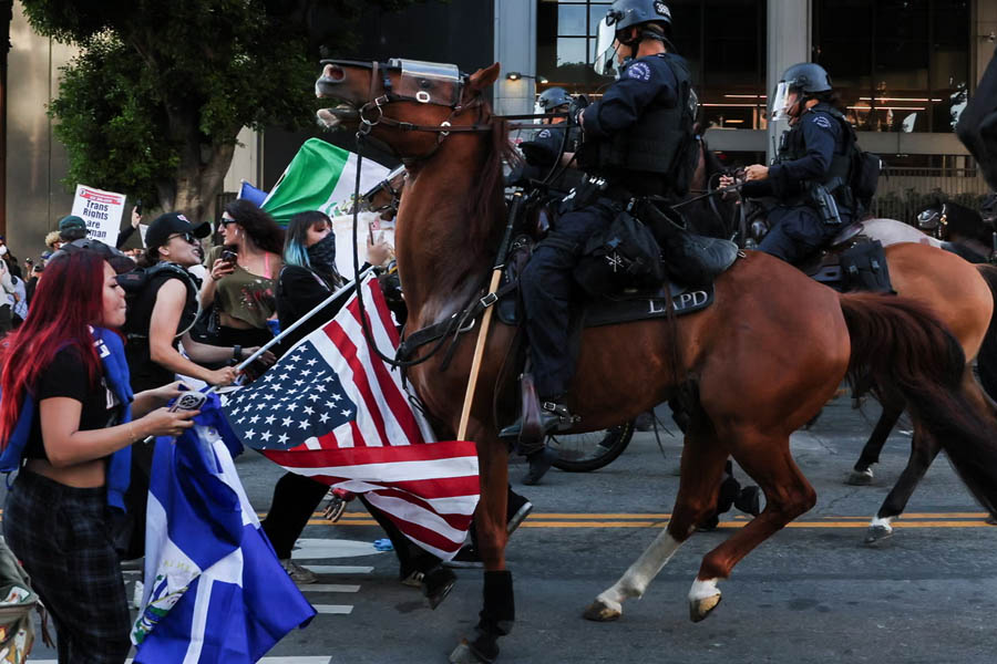 A curfew has come into effect for the second consecutive night in downtown Los Angeles, where police used horses and munitions to disperse protesters.