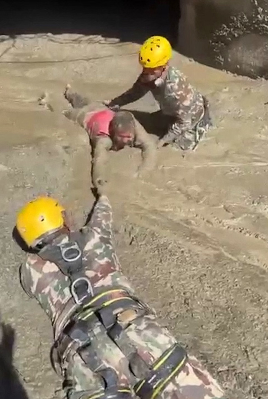 Rescuers pull a person trapped inside the tunnel.