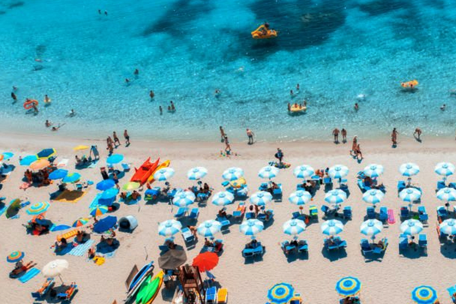 Colorful umbrellas on a sandy beach in Sardinia, Italy. Under new rules at Punta Molentis beach, only children under 10 and adults over 65 are permitted to use umbrellas.