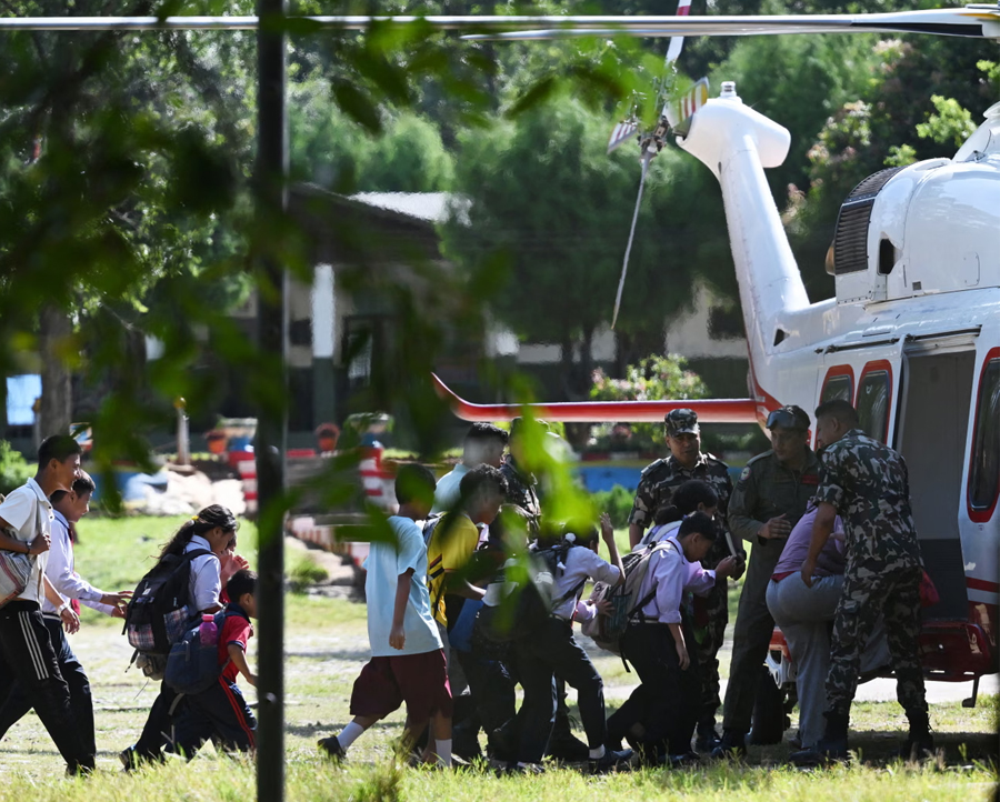 School children board a helicopter on a transit flight back to their family at Trishuli camp after being stranded by the flash flooding in Nepal's Nuwakot district.