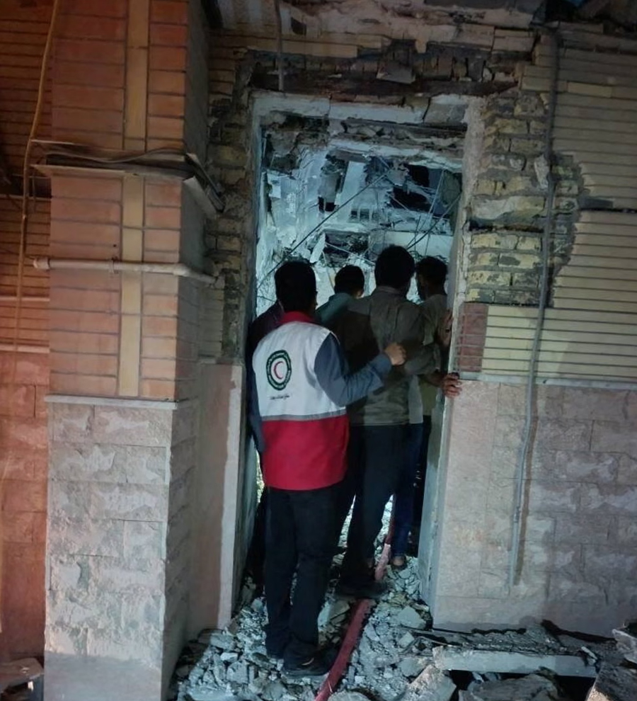 People gather at the site of a reported attack in Sirik, Iran.