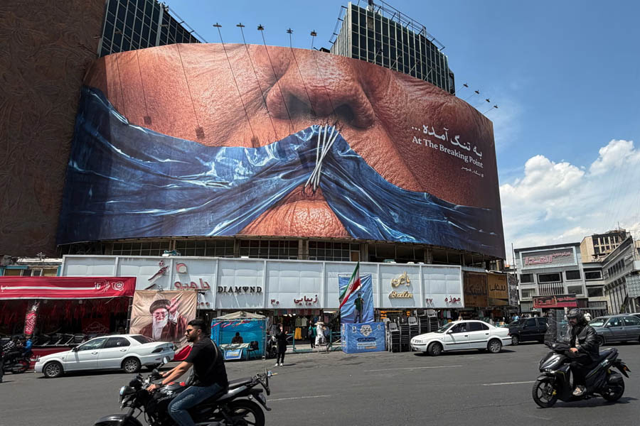 Vehicles drive past a billboard with an image of the Strait of Hormuz and sewn lips of Donald Trump in a square in central Tehran, Iran, at the weekend.