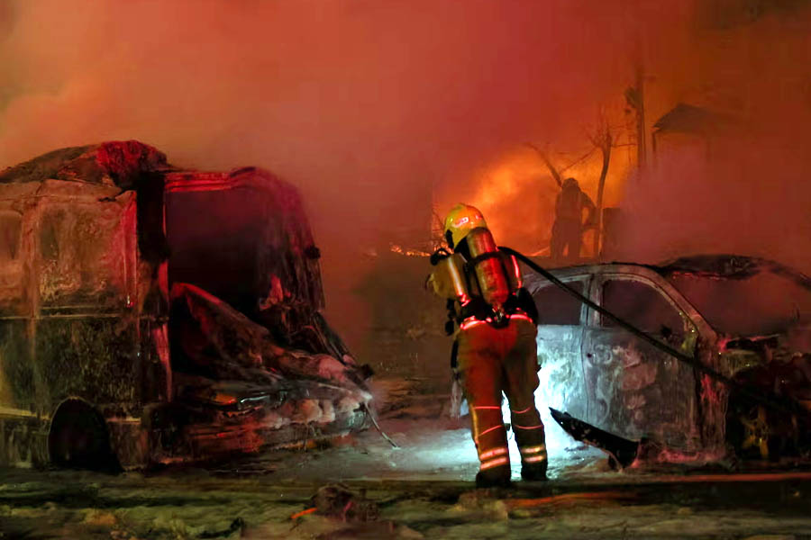 Emergency workers operate near the wreckage of destroyed vehicles after missiles were launched from Iran to Israel, in Tel Aviv