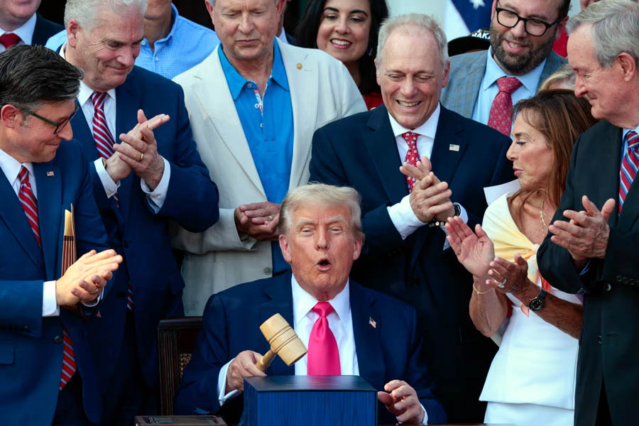 President Donald Trump smiles proudly after signing his 