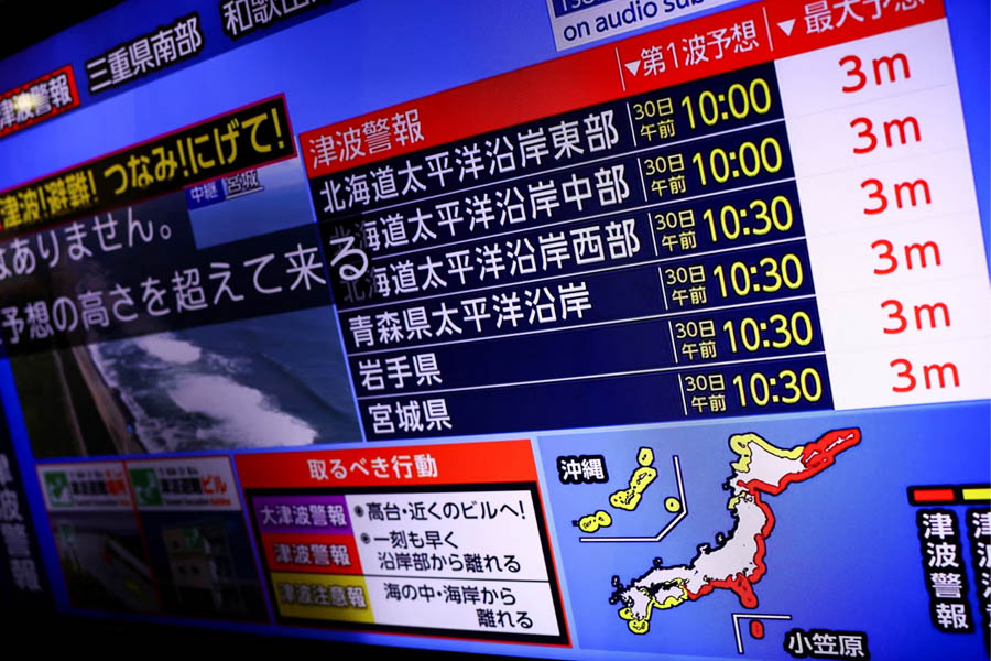 A television screen displays a news report about the tsunami warning in Japan, issued after a powerful earthquake struck off Russia’s Kamchatka Peninsula.
