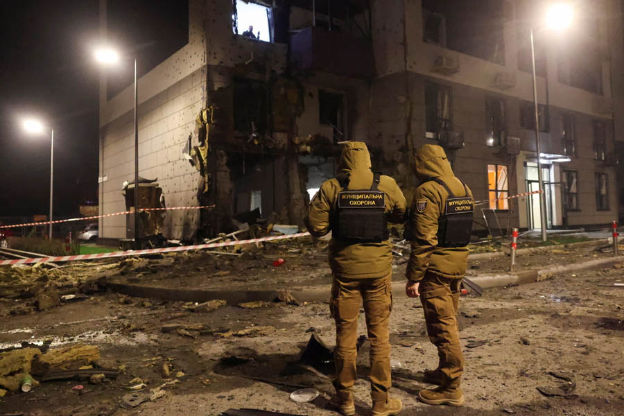 Ukrainian servicemen standing amid debris at an apartment building damaged by a Russian missile and drone attack in Kyiv.