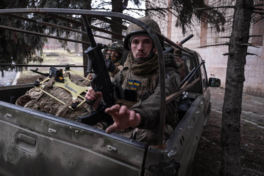 Ukrainian soldiers sitting in the back of a military truck driving through Druzhkivka in the Donetsk region near the eastern frontline.