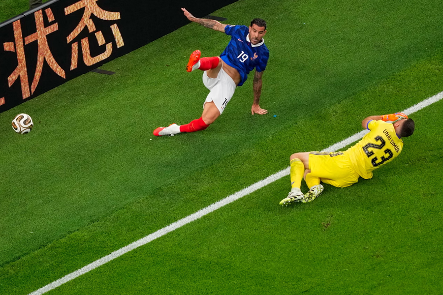 Spain's goalkeeper Unai Simon falls after colliding with France's Theo Hernandez