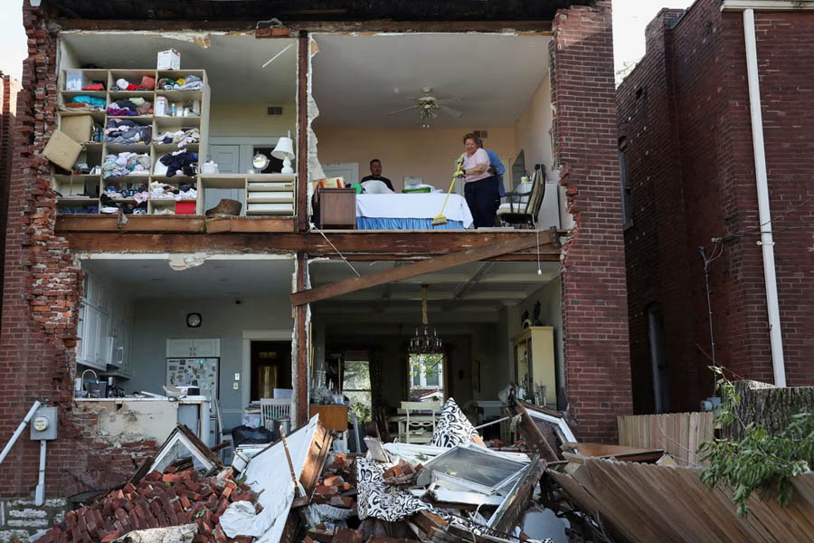 Residents inspect their home after a tornado tore off the back wall of a house in St Louis, Missouri, on 16 May.
